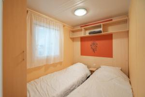 two beds in a small room with a window at Mh 61 La Tremblade in La Tremblade