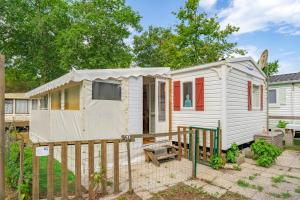 a small white tiny house in a yard at Mh 61 La Tremblade in La Tremblade +12 photos