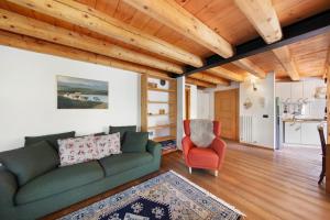a living room with a green couch and a red chair at Villa Cleila Verde B in San Vito di Cadore