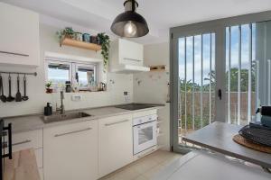 a kitchen with white cabinets and a large window at Villa en Taro in Güimar