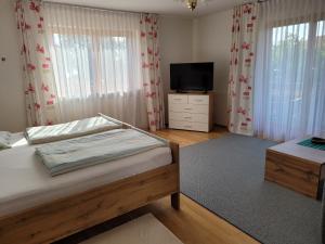 a bedroom with a bed and a flat screen tv at Ferienwohnung bei Helga in Tittmoning