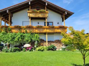 a house with a balcony with flowers on it at Ferienwohnung bei Helga in Tittmoning