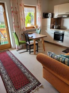 a living room with a table and a kitchen at Ferienwohnung bei Helga in Tittmoning