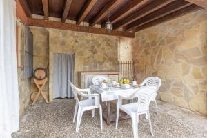 a white table and chairs in a room with a stone wall at Como En Casa Jerez in Jerez de la Frontera