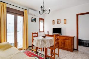 a living room with a table and a tv at Casa Ángela in Conil de la Frontera