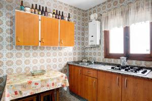 a kitchen with wooden cabinets and a table in it at Casa Ángela in Conil de la Frontera +12 photos