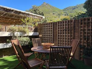 a patio with a table and chairs and a fence at Leehaven in Hout Bay +19 photos