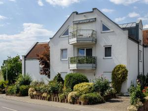 a white house with plants in front of it at Tulips Apartment in Meckenbeuren