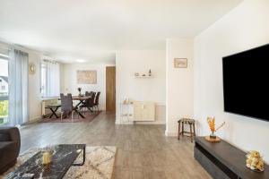 a living room with a flat screen tv on a wall at Tulips Apartment in Meckenbeuren