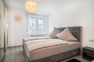 a bed in a room with a chandelier at Tulips Apartment in Meckenbeuren