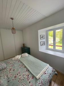 a bedroom with a bed and a window at Maison de campagne in Séneujols