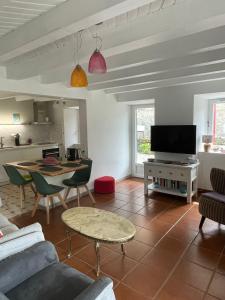 a living room with a couch and a table at Maison de campagne in Séneujols