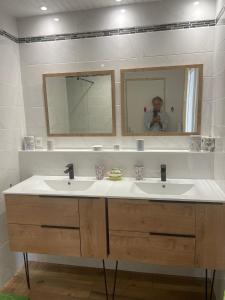 a man taking a picture of a bathroom with two sinks at Maison de campagne in Séneujols +24 photos