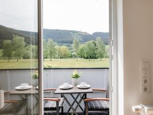 a room with a table and chairs and a large window at Ferienwohnung Kurparkblicksauerland in Lennestadt