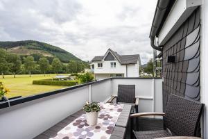 a balcony with two chairs and a table at Ferienwohnung Kurparkblicksauerland in Lennestadt +25 photos