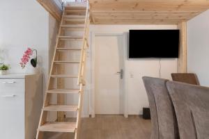 a wooden staircase in a living room with a tv at Fewo Mca in Rielasingen-Worblingen
