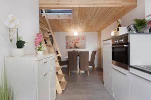 a kitchen with white cabinets and a wooden ceiling at Fewo Mca in Rielasingen-Worblingen