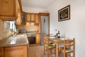 a kitchen with wooden cabinets and a table with chairs at Casa Nanda in Fasnia