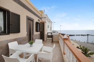 a balcony with a white table and chairs and the ocean at Casa Nanda in Fasnia