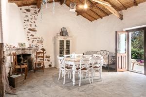 a white dining room with a table and chairs at Casa vacanza Stazzu Saiacciu in Palau