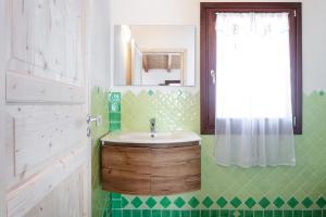 a bathroom with a sink and a mirror at Casa vacanza Stazzu Saiacciu in Palau +20 photos