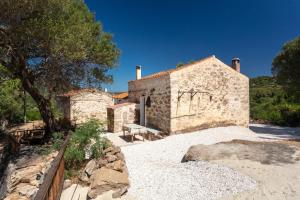 a stone house with a bench in front of it at Casa vacanza Stazzu Saiacciu in Palau