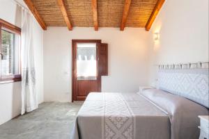 a bedroom with a bed and a window and a door at Casa vacanza Stazzu Saiacciu in Palau