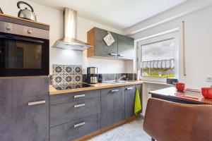 a kitchen with gray cabinets and a sink and a window at Ferienwohnung Wilde Schanze in Hoppecke