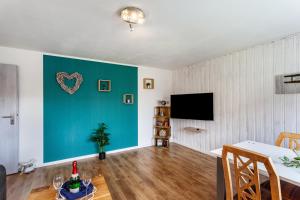 a living room with a table and a blue wall at Ferienwohnung Wilde Schanze in Hoppecke
