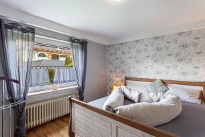 a bedroom with a bed with a large window at Ferienwohnung Wilde Schanze in Hoppecke +13 photos