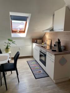 a small kitchen with a stove and a table at Mein kleines Reich in Zwickau