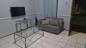 a living room with a couch and a table and a tv at Pendleberry Unit 85 in Warmbaths