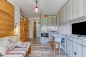 a living room with a couch and a tv and a kitchen at Studio équipé Avec Balcon Fermé in La Morte