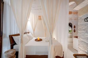 a bedroom with a white bed with a window at Archè Luxury private Spa in Polignano a Mare