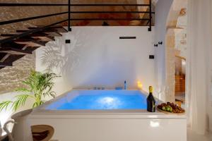 a hot tub in a room with a bottle of wine at Archè Luxury private Spa in Polignano a Mare