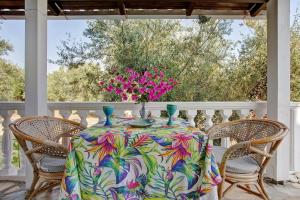 a table on a porch with a vase of flowers at Areti Orfeas Apartment 7 in Vasilikos