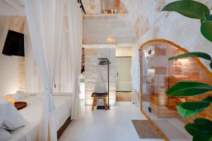 a hotel room with a bed and a mirror at Archè Luxury private Spa in Polignano a Mare
