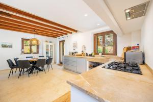 a kitchen and dining room with a stove and a table at Sa Papaiona in Valldemossa