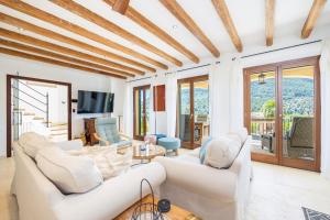 a living room with white furniture and sliding glass doors at Sa Papaiona in Valldemossa
