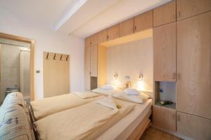 a large bed in a room with wooden cabinets at Residence Pichler Apartment 7 in San Leonardo in Passiria