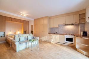 a kitchen and living room with a couch and a table at Residence Pichler Apartment 7 in San Leonardo in Passiria +9 photos
