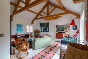 a living room with a green couch and wooden ceilings at Surfers Roost in Croyde