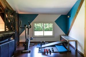 a room with a gym with a treadmill and a window at Chambre Chene in Mauléon-dʼArmagnac