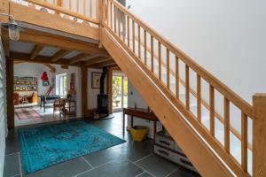 a wooden staircase in a house with a living room at Surfers Roost in Croyde
