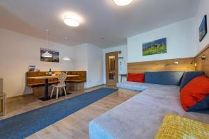a living room with a blue couch and a desk at Gass Apartment B in Laion