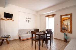 a living room with a table and chairs and a couch at Afroksilia Villa Gardenia in Lefkada