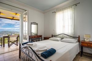 a bedroom with a bed and a balcony at Afroksilia Villa Gardenia in Lefkada +16 photos