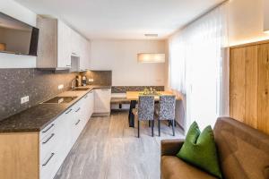 a kitchen with a couch and a table in a room at Zum Sonnentor App Larix 2 in Lutago