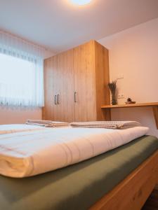 a large bed in a room with a window at Zum Sonnentor App Larix 2 in Lutago