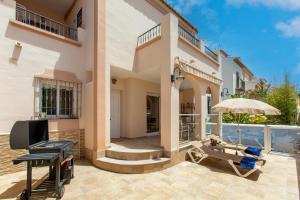 a house with a patio with a table and an umbrella at Villa Palomas in Nerja